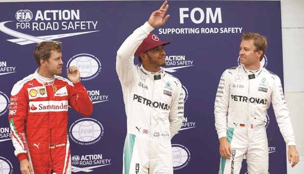 Ferrari driver Sebastian Vettel (L), and Mercedes Benz drivers Lewis Hamilton (C) and Nico Rosberg pose after qualifying session yesterday. (Reuters)