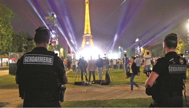 Gendarmes stand guard near the Eiffel Tower during the France vs Romania match.