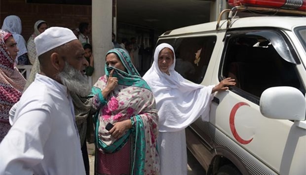 Pakistani relatives stand alongside an ambulance carrying the body of a young woman outside a hospital in Islamabad on Wednesday.