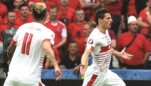 Switzerlandu2019s defender Fabian Schaer (R) celebrates with teammate Valon Behrami after scoring a goal during the group A match against Albania yesterday.