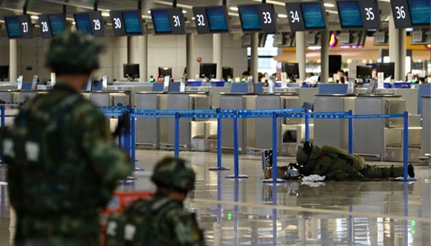 A paramilitary bomb disposal expert (background R) inspects luggage left near a check-in counter after an explosion at Pudong Airport in Shanghai.