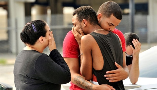 Friends and family members embrace outside the Orlando Police Headquarters during the investigation of a shooting at the Pulse night club