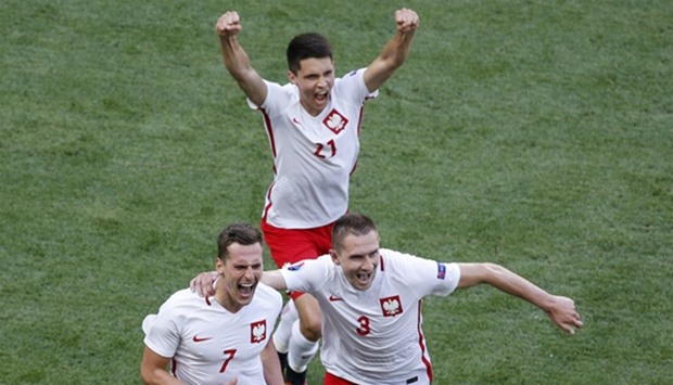 Poland's Arkadiusz Milik (L) celebrates with Artur Jedrzejczyk (R) and Bartosz Kapustka after scorin