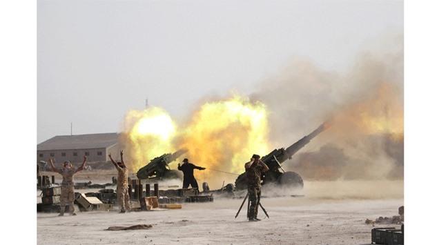 Iraqi security forces and Shia fighters fire artillery towards Islamic State militants near Fallujah, Iraq, yesterday.
