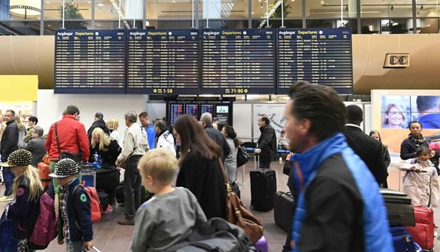 Passengers wait for flight information at Arlanda Airport