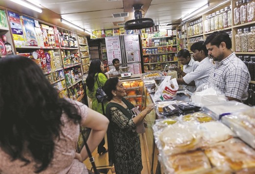 People shop inside a grocery store at a residential area in Mumbai. Food inflation in India picked up to 7.55% in May from an upwardly revised 6.40% in the previous month, as prices of vegetables, sugar and pulses rose between 11% and as much as 32% from a year ago.