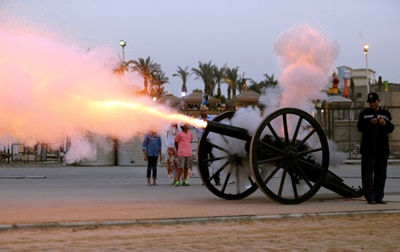 An Egyptian family watches as a cannon fires to announce the time to break the fast during the Ramadan in Cairo yesterday.
