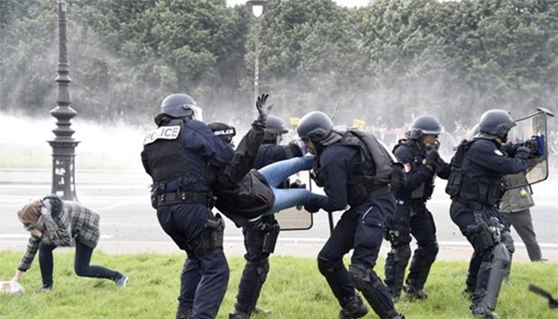 Police officers detain a demonstrator during clashes near the Invalides in Paris on Tuesday.