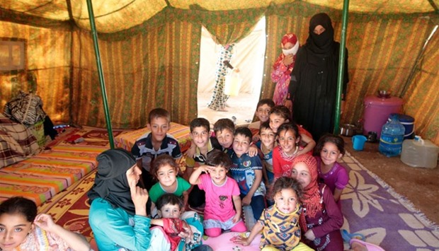 Iraqi women and children, who fled the ongoing fighting between government forces and Islamic State (IS) group jihadists in the Fallujah area, sit inside a tent at a camp for displaced people in Amriyat al-Fallujah on June 14, 2016.