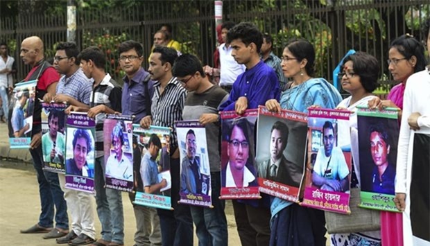 Bangladeshi activists hold photos of writers and bloggers who were murdered in the last few years, in Dhaka on Wednesday.