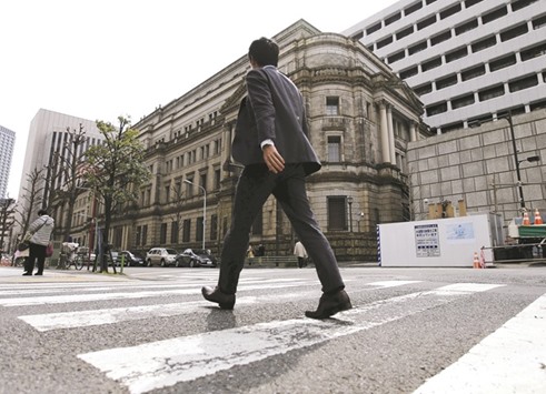 A businessman walks past the Bank of Japan building in Tokyo. The BoJ is ready to offer dollar funds to domestic banks via auctions if a so-called Brexit scares investors into hoarding the US currency, said officials with direct knowledge of preparations yesterday.