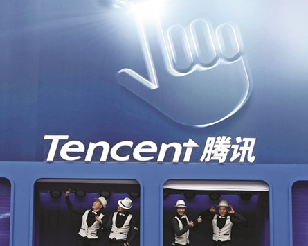 Dancers perform underneath the logo of Tencent at a global mobile Internet conference in Beijing (file). Tencent plans to buy the 73.2% stake in Supercell from Japanese media and telecoms company SoftBank Group Corp, valuing the maker of the popular mobile game u2018Clash of Clansu2019 at more than $9bn, a source said.