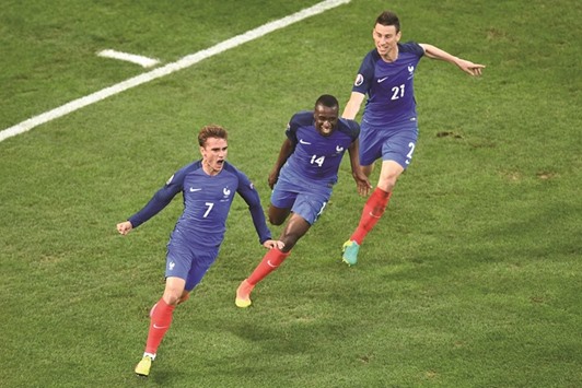 France forward Antoine Griezmann (left) celebrates with teammates Blaise Matuidi and Laurent Koscielny (right) after scoring against Albania. (AFP)