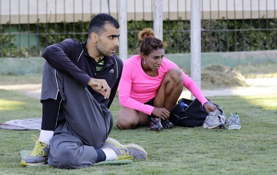 In this June 12, 2016, picture, Syrian high jump athlete Majd Ghazal and hurdler Ghafran Mohamed (right) get ready for a training session at Tishrin Stadium in Damascus. The duo is hoping to bring a rare moment of happiness to a country submerged in violence for the last five years. (AFP)