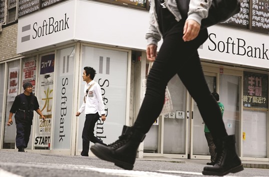People walk past a retail shop of the SoftBank in Tokyo. The Japanese mobile giant has picked up an assortment of firms in recent years, including its $16bn purchase of US-based mobile giant Sprint.