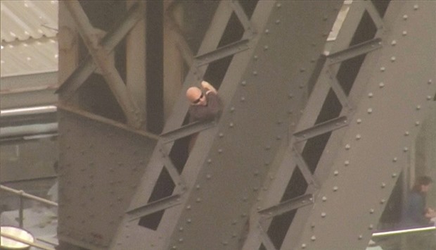 A man climbs the arch of the Sydney Harbour Bridge, in this still image taken from video yesterday.