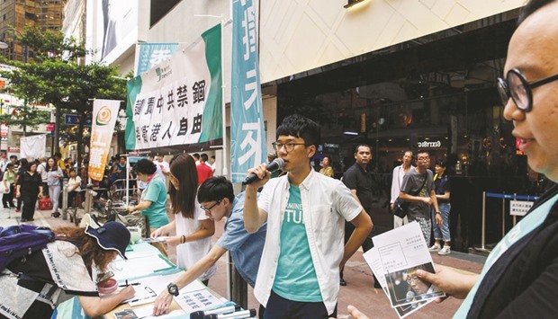Pro-democracy activist and member of political group Demosisto, Nathan Law (centre) invites members of the public to sign a petition in support of freedom of press and speech and for the missing and returned booksellers, outside the Causeway Bay Bookstore in Hong Kong yesterday.