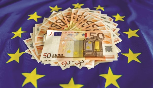 The new 50-euro notes that the European Central Bank plans to issue next year are displayed on an European Union flag.