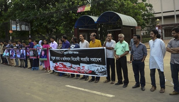 Bangladeshi activists hold the photos of activists, writers and bloggers who were murdered by uniden