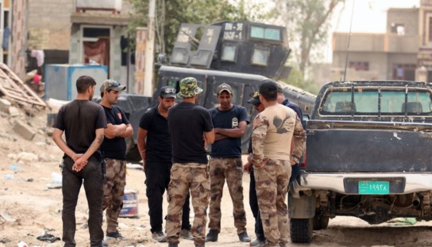 Members of the Iraqi counter terrorism forces gather next to their vehicles in Fallujahh's southern Shuhada neighbourhood as they patrol an area they retook from the Islamic State (IS) group.