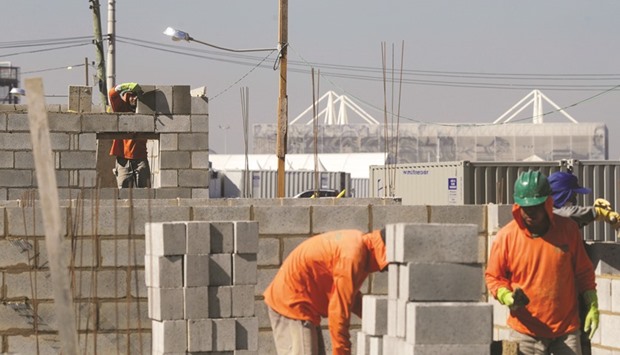 Men work on the construction of new houses for families, who refused to leave the Vila Autodromo that was surrounded by construction work for the 2016 Rio Olympic park.