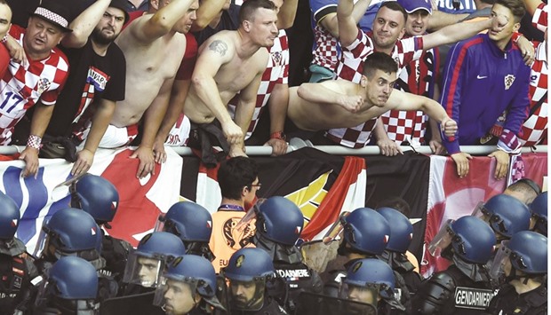 Croatia fans taunt French riot police after flares were thrown onto the pitch during the Group D match between Czech Republic and Croatia in Saint-Etienne. (AFP)