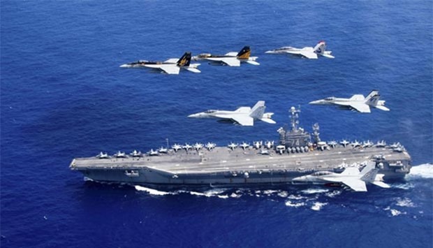 A combined formation of aircraft from Carrier Air Wing (CVW) 5 and  CVW 9 pass in formation above the Nimitz-class aircraft carrier USS John C. Stennis (CVN 74) in the Philippine Sea on Saturday.