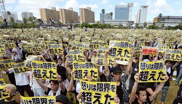 Protesters raise placards reading ,Anger was over the limit, during a rally against the US military presence, at a park in Naha on Okinawa, Japan on Sunday.