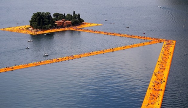 People walk on the monumental installation entitled 'The Floating Piers' created by artist Christo V
