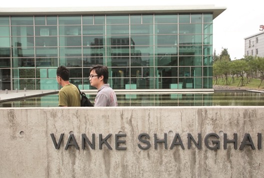 Pedestrians walk past the China Vanke headquarters in Shanghai. Vanke chairman Wang Shiu2019s bid to fend off a takeover has been thrown into doubt after the property developeru2019s second-largest shareholder, China Resources, said the proposal failed to get enough votes from the board.