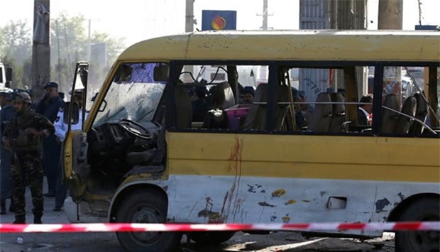 Afghan security forces inspect damage to a minibus hit by a suicide attacker in Kabul on Monday.