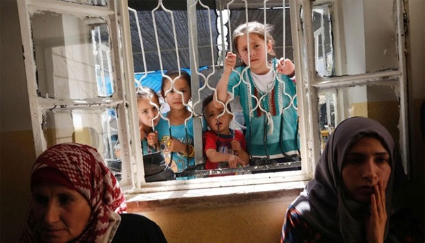 Palestinian children look through the window at mourners grieving the death of Aref Jaradat, a 22-year old Palestinian who was injured during clashes with Israeli security forces in May 2016, prior to his funeral in Sair village east of the West Bank city of Hebron on June 20, 2016.