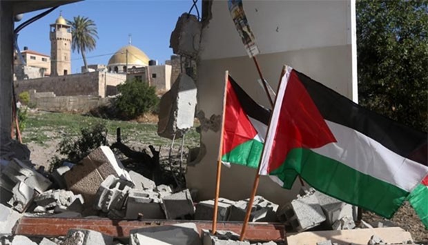 Palestinian flags are seen on the rubble of a house after it was demolished by Israeli security forces in the village of Haja, in the West Bank, on Tuesday.