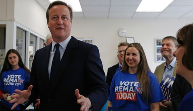 Britain's Prime Minister David Cameron gestures while speaking with campaign volunteers