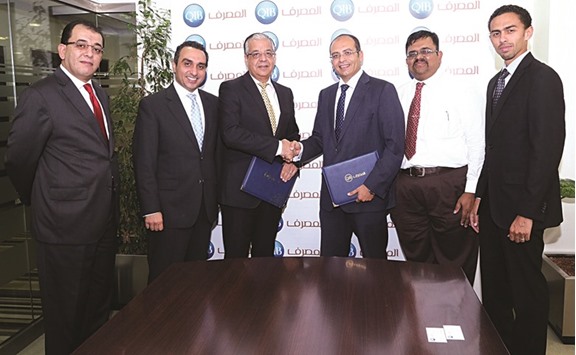QIB general manager of Wholesale Banking, Tarek Fawzi; and Jaidah Equipment managing director, Ayman Ahmed; shake hands after the signing ceremony.