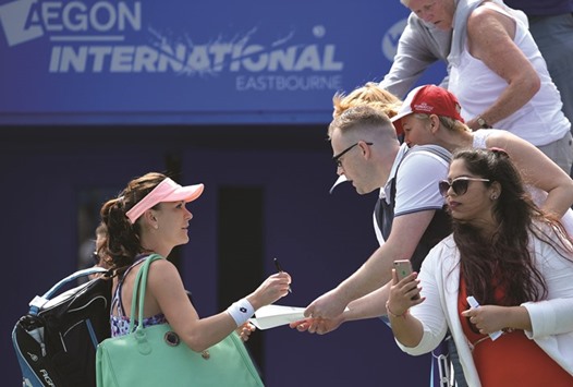 Polandu2019s Agnieszka Radwanska (left) signs autographs after beating Croatiau2019s Mirjana Lucic-Baroni in their second round match at WTA Eastbourne International yesterday. (AFP)