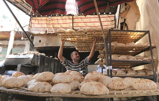 An Egyptian baker is seen beside a vegetable market in Cairo.