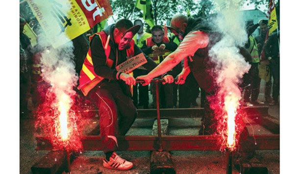 Striking employees of the French state-owned rail operator SNCF install rails in front of the MEDEFu2019s (French employersu2019 association) branch in Lyon yesterday.