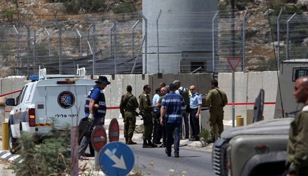 Israeli security forces inspect the scene of a stabbing attack at a checkpoint near the West Bank city of Tulkarem