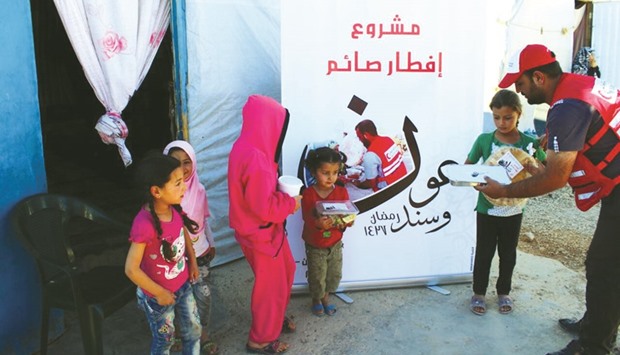 QRCS staff distributes meals to young children in Arsal.
