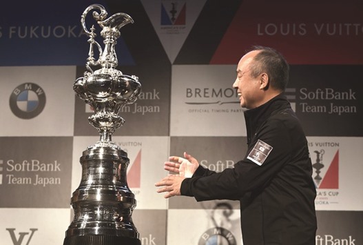 SoftBank Group representative Masayoshi Son poses next to the Americau2019s Cup trophy during a press conference yesterday. (AFP)