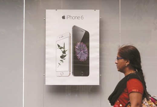 A pedestrian walks past an Apple iPhone 6 advertisement at an electronics store in Mumbai. The Silicon Valley giant applied to open stores in India in January, but was reportedly rebuffed because of a diktat that states foreign retailers must source 30% of their products locally.