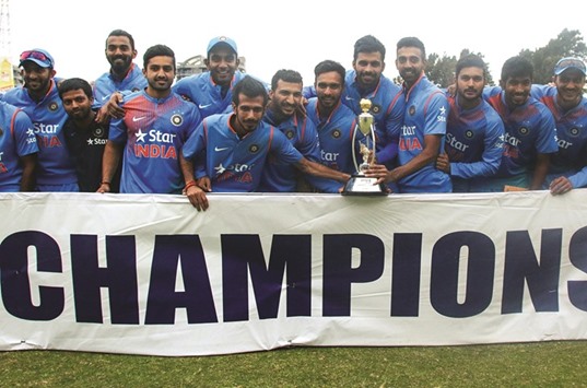 Indiau2019s players pose with the winnersu2019 trophy after beating Zimbabwe in the third T20 International in Harare yesterday. (AFP)