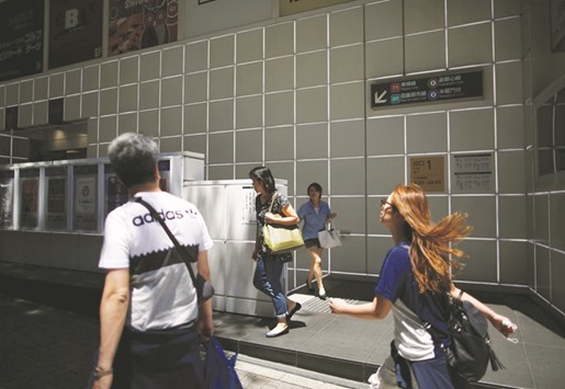 People walk on a street at Shibuya shopping and amusement district in Tokyo. Japanu2019s government approved an economic growth strategy yesterday that failed to show how it will plug a hole in  finances caused by delaying a sales tax increase, raising fears  that an already alarmingly high public debt burden will worsen.
