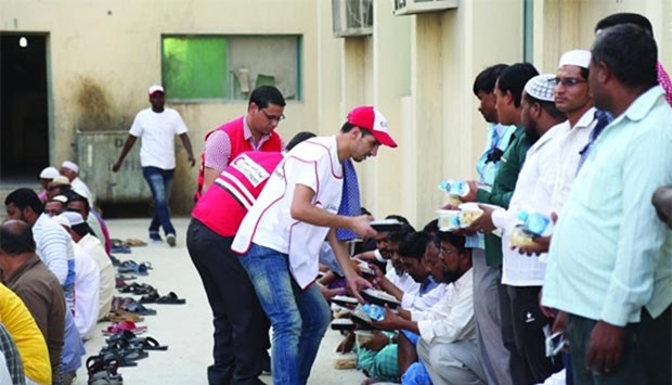 QRCS staff distributes Iftar meals to workers.