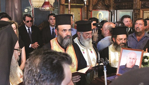 Relatives, friends and Cypriot President Nicos Anastasiades (left) attending the funeral of Marios Aristotelous, a Cypriot firefighter who died while fighting a blaze raging in the northern foothills of the Troodos mountains, at the Charalambos church in Deneia, west of the capital Nicosia.
