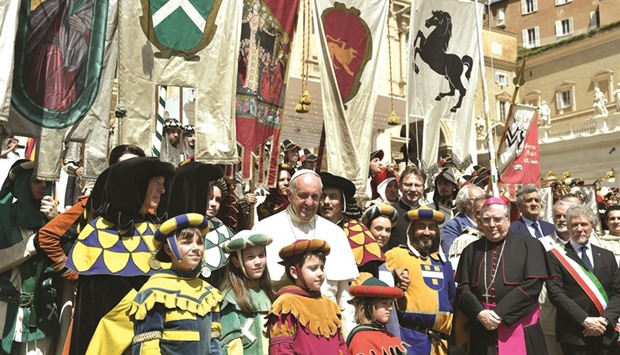 Pope Francis poses with a group of flag-bearers from Arezzo at the end of his weekly general audience at St Peteru2019s square in Vatican yesterday.