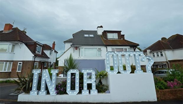 An illuminated \"In or Out\" sign is pictured outside a house in Hangleton near Brighton in southern England, on Thursday, as Britain holds a referendum on whether to stay or leave the European Union.