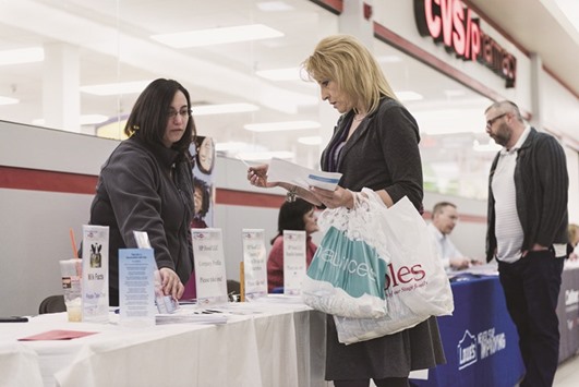 A job seeker, right, speaks with a representative at the Laconia Job & Resource Fair, hosted by the New Hampshire Employment Security, at Belknap Mall in Belmont. The four-week moving average of jobless claims, considered a measure of labour market trends as it irons out week-to-week volatility, fell 2,250 to 267,000 last week.