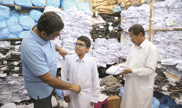 A boy tries out a dress at a shop in Doha.